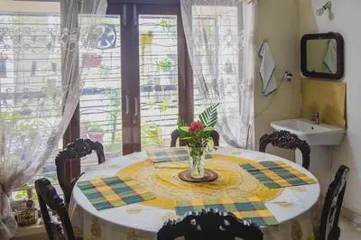 a dining room table with a vase of flowers on it at Homestay for Women in Coimbatore