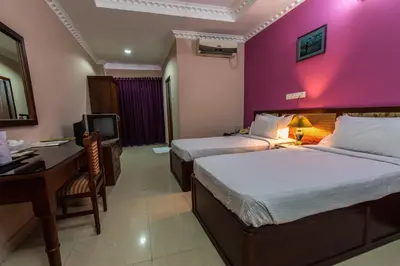 a hotel room with two beds and a desk and a computer at Kallada Hotels and Resorts in Trichūr