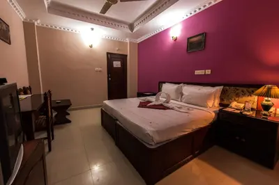 a bedroom with a bed with a purple wall at Kallada Hotels and Resorts in Trichūr