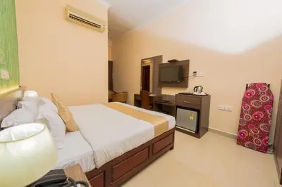 a hotel room with a bed and a television at Kallada Golden Hotel in Trichūr