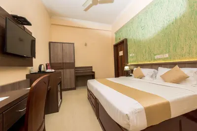 a bedroom with a bed and a flat screen tv at Kallada Golden Hotel in Trichūr