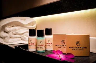a group of four products sitting on a table with a pink flower at Golden Fern Resort in Kanthalloor