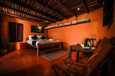 a bedroom with a bed and a table at Golden Fern Resort in Kanthalloor