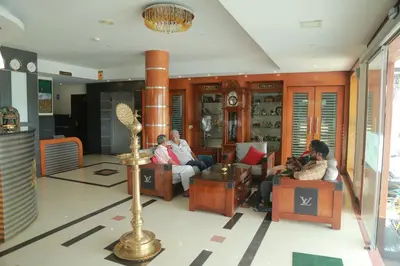 a group of people sitting in a living room at Hotel Jyothis Regency in Palakkad
