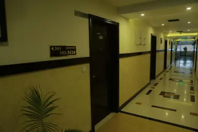 a hallway of a building with a sign on the wall at Hotel Jyothis Regency in Palakkad
