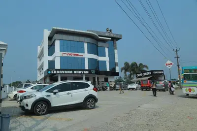 a white car parked in front of a building at Hotel Jyothis Regency in Palakkad