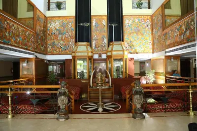 a large room with colorful walls and ceilings with furniture at Mayura Residency in Guruvāyūr