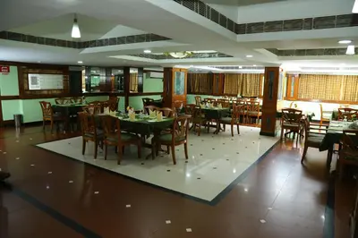 a dining room with tables and chairs in a restaurant at Mayura Residency in Guruvāyūr