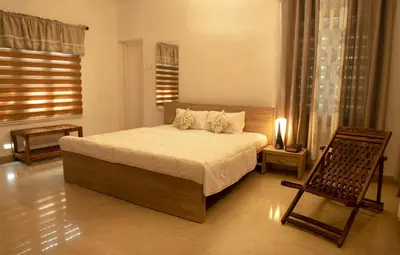 a bedroom with a bed and a chair and a window at Gloria Homestay ,Thrissur - Pooram Bookings open Apr 25-27 in Trichūr