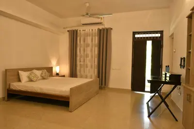 a bedroom with a bed and a desk and a window at Gloria Homestay ,Thrissur - Pooram Bookings open Apr 25-27 in Trichūr
