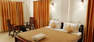 a bedroom with a bed with pillows and a table at Oxxon Airport Hotel in Angamali
