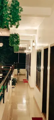 a hallway of a building with potted plants in it at Oxxon Airport Hotel in Angamali
