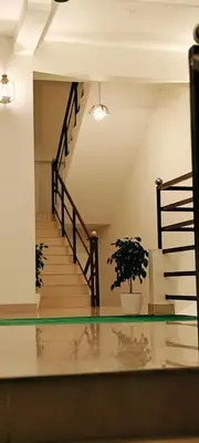 a hallway with stairs and a potted plant at Oxxon Airport Hotel in Angamali