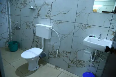 a bathroom with a toilet and a sink at Oxxon Airport Hotel in Angamali