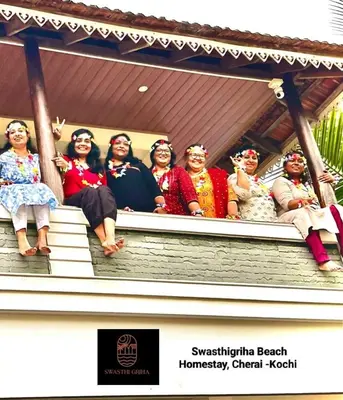 a group of women sitting on the steps of a house at Swasthigriha's Beach Homestay, Cherai in Cherai Beach