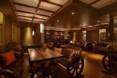 a restaurant with a wooden table and chairs at Sinclairs Retreat Ooty in Ooty