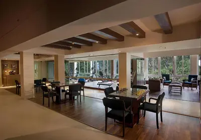 a lobby with tables and chairs and a living room at Sinclairs Retreat Ooty in Ooty