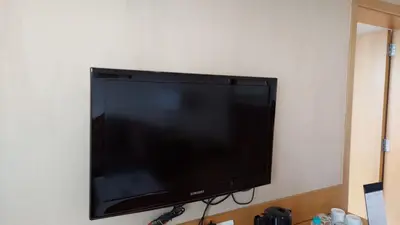 a flat screen tv hanging on a wall at Mysore County Retreat in Mysore