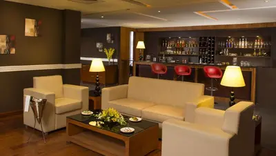 a living room with a couch and a bar at Mysore County Retreat in Mysore