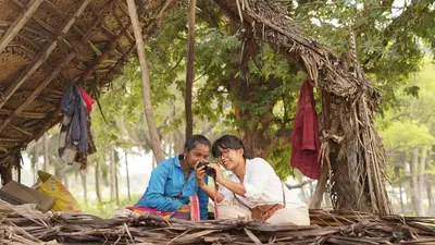 two women sitting in a straw hut taking a picture at SpiceTree Chinnar in Dhali