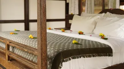 a bed with flowers on top of it at SpiceTree Chinnar in Dhali