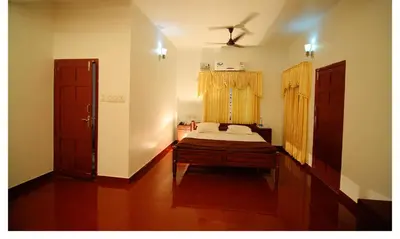 a bedroom with a bed and a window at Ayuryogashram Heritage in Trichūr