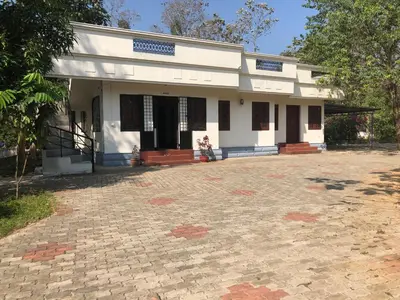 a white building with a brick driveway in front of it at Ayuryogashram Heritage in Trichūr