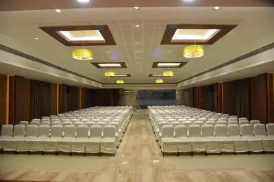 an empty room with white chairs in a theater at Rathna Residency in Erode