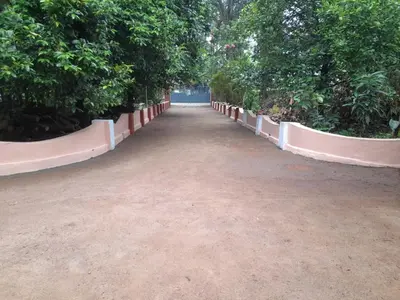 a pathway with trees and a dirt road at Back Packers Cochin Villa in Cochin
