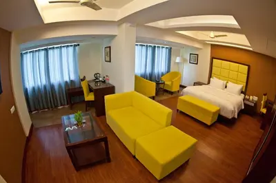 a hotel room with a bed and a couch and a table at Paramount Tower in Kozhikode