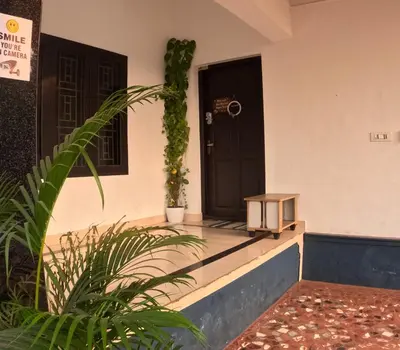 a front door of a house with a plant at 7TH HEAVEN Kannur in Chakkarakkal