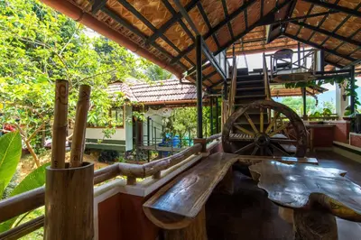 a wooden bench in a room with a wooden wheel at Olives The Boutique Resort in Kalpetta