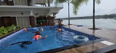 two people playing in a swimming pool on a resort at SAGAR BEACH VILLAS Home stay in Cherai Beach