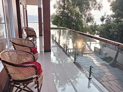 a balcony with chairs and a view of the water at SAGAR BEACH VILLAS Home stay in Cherai Beach