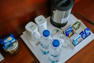 a table with a coffee maker and bottles of water at Hotel Devaragam by K P Namboodiri's in Guruvāyūr
