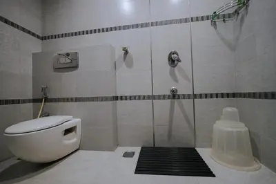 a bathroom with a shower and a toilet in it at Hotel Devaragam by K P Namboodiri's in Guruvāyūr