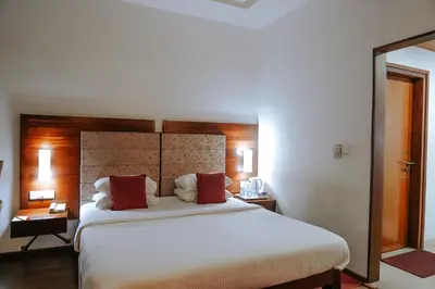 a bedroom with a large white bed with red pillows at Hotel Devaragam by K P Namboodiri's in Guruvāyūr