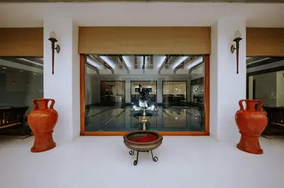 a room with two vases and a table in front of a window at Hotel Devaragam by K P Namboodiri's in Guruvāyūr