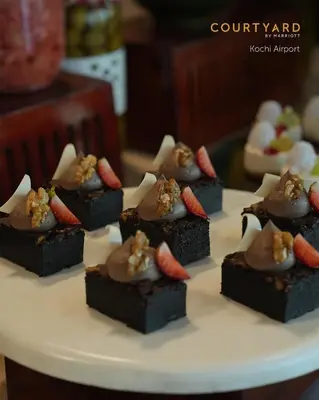 a bunch of chocolate desserts on a white plate at Courtyard by Marriott Kochi Airport in Nedumbassery