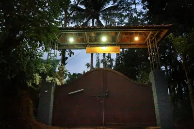 a gate with a bridge above it with a building at Keloth Tharavadu in Panamaram