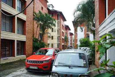 two cars parked on a street next to buildings at Vrindavan Suites Guruvayur in Guruvāyūr