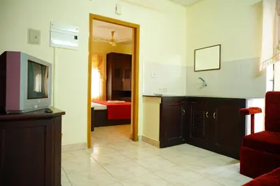 a kitchen with a television and a counter top at Vrindavan Suites Guruvayur in Guruvāyūr