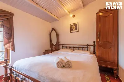 a bedroom with a bed with towels on it at Greenwood Bungalow Heritage In the heart of Ooty in Ooty