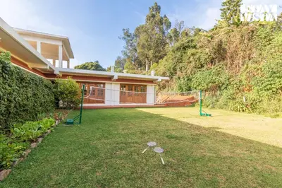 a house with a yard with a net at Greenwood Bungalow Heritage In the heart of Ooty in Ooty
