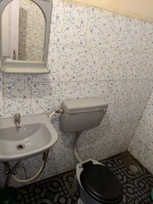 a bathroom with a toilet and a sink at REFLECTIONS Guest House in Ooty