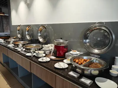 a kitchen with many pots of food on a counter at The Mayberry -A Bergamont Group of Hotels in Tiruppūr