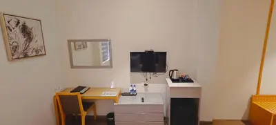 a room with a desk with a computer and a tv at The Mayberry -A Bergamont Group of Hotels in Tiruppūr