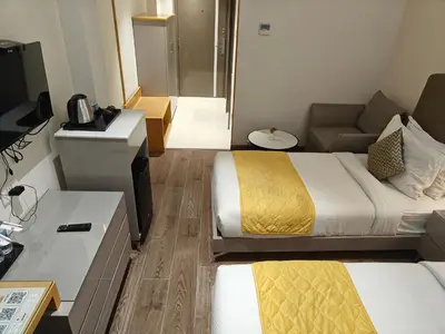 a hotel room with two beds and a couch at The Mayberry -A Bergamont Group of Hotels in Tiruppūr