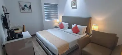 a hotel room with a bed and a chair at The Mayberry -A Bergamont Group of Hotels in Tiruppūr