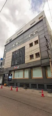 a large building with orange cones in front of it at The Mayberry -A Bergamont Group of Hotels in Tiruppūr